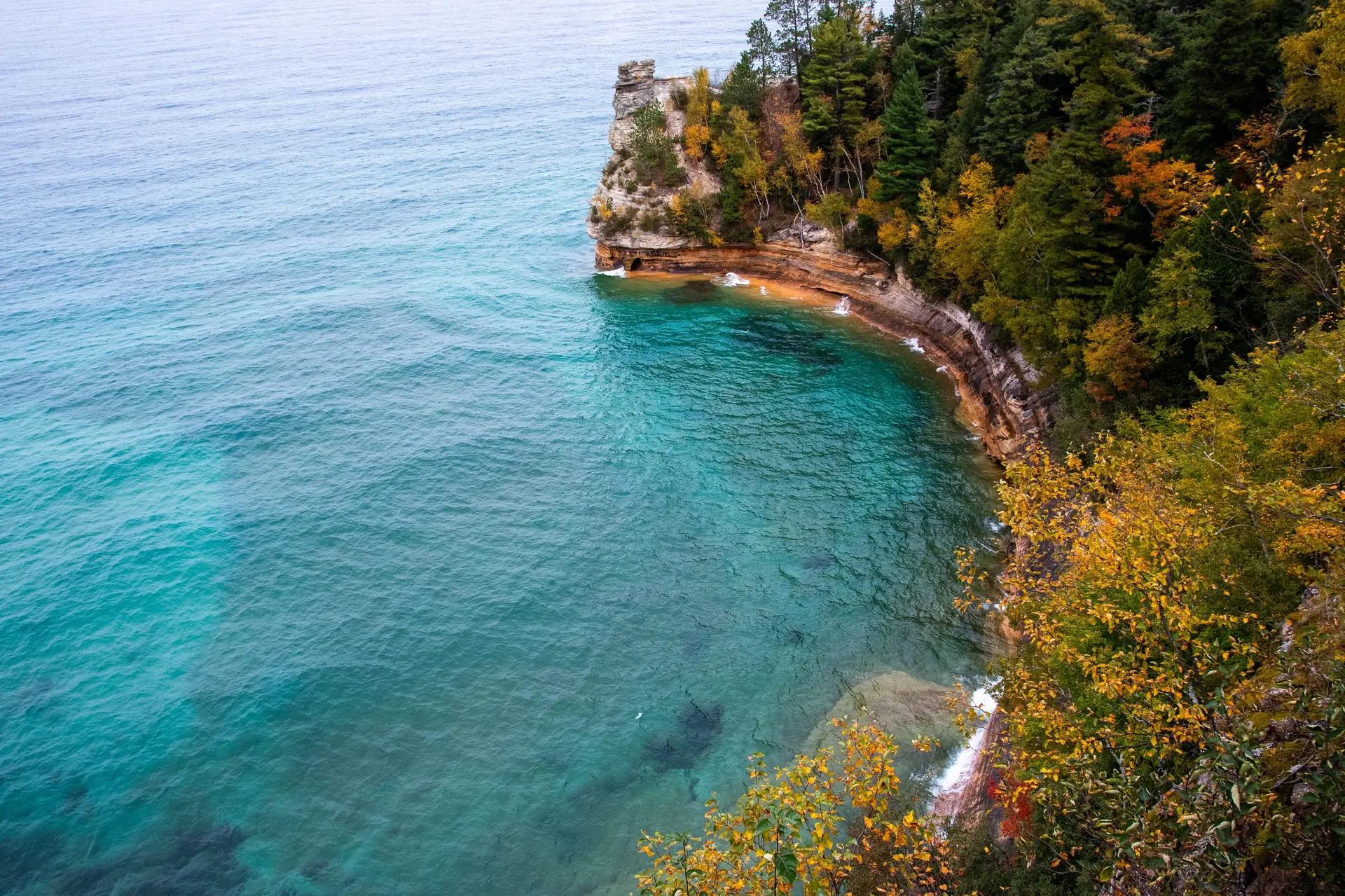 Turquoise Lake Superior shoreline below sandstone cliffs on the Michigan coast
